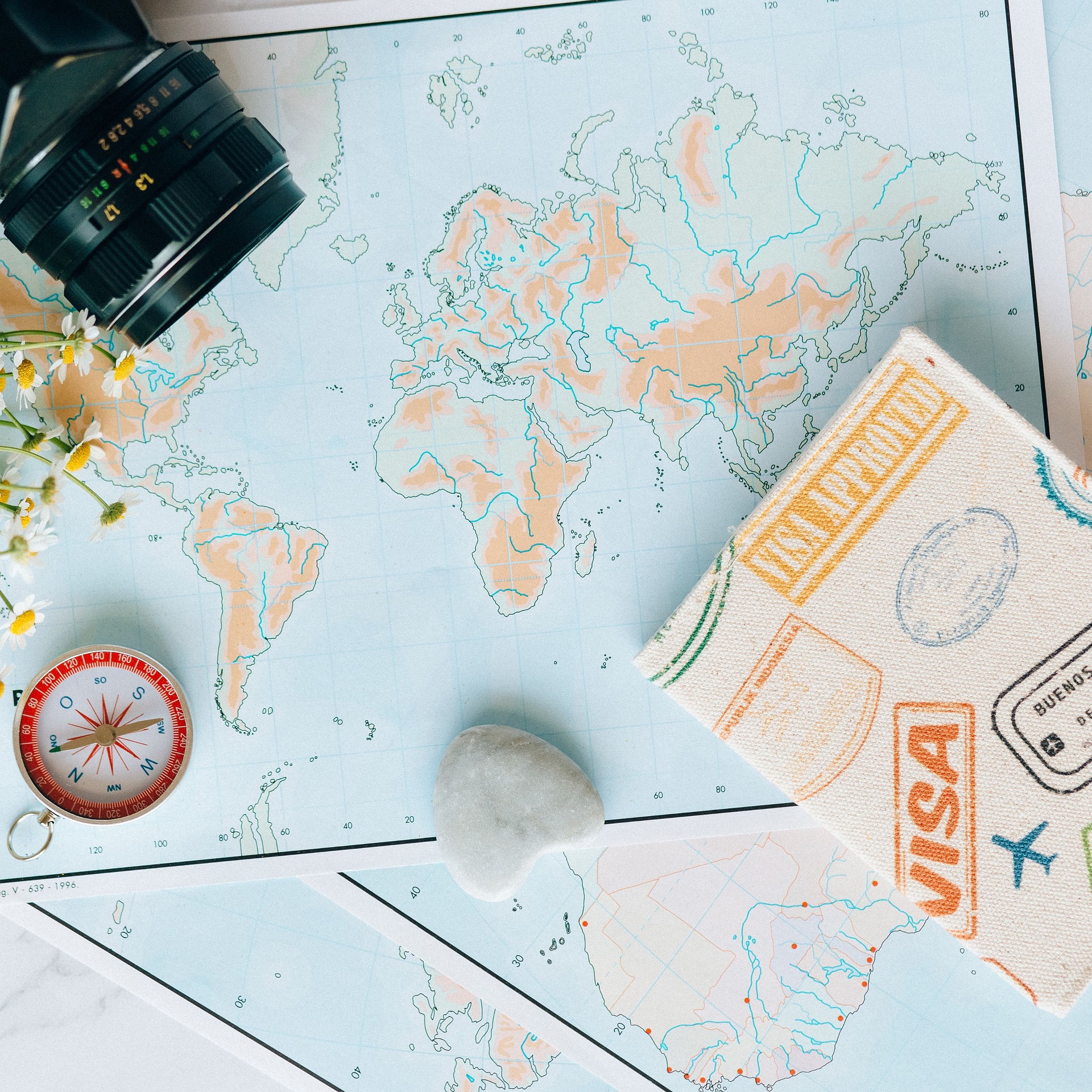 A world map covered in visa stamps beside a passport